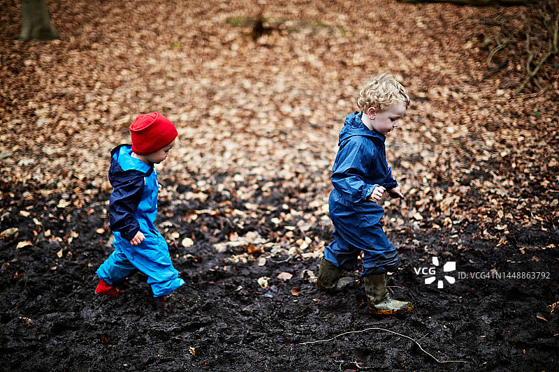 两个在泥地里行走的男孩图片素材