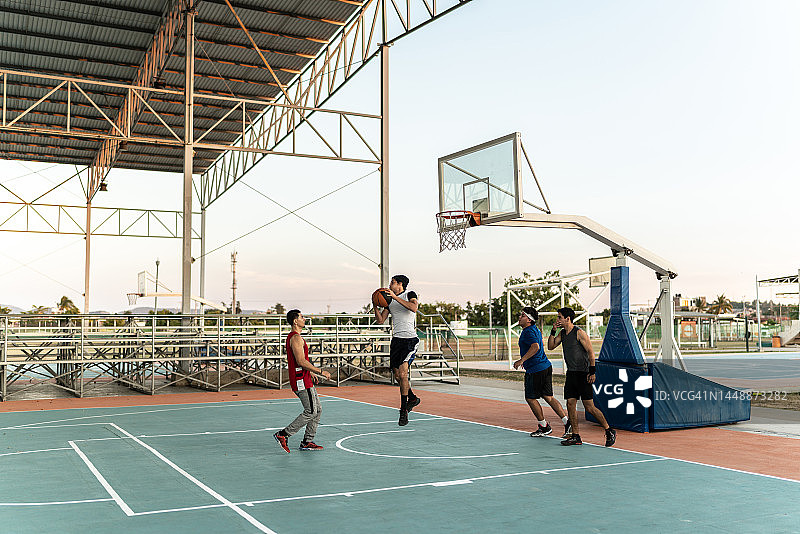 年轻朋友在运动场上打篮球比赛图片素材