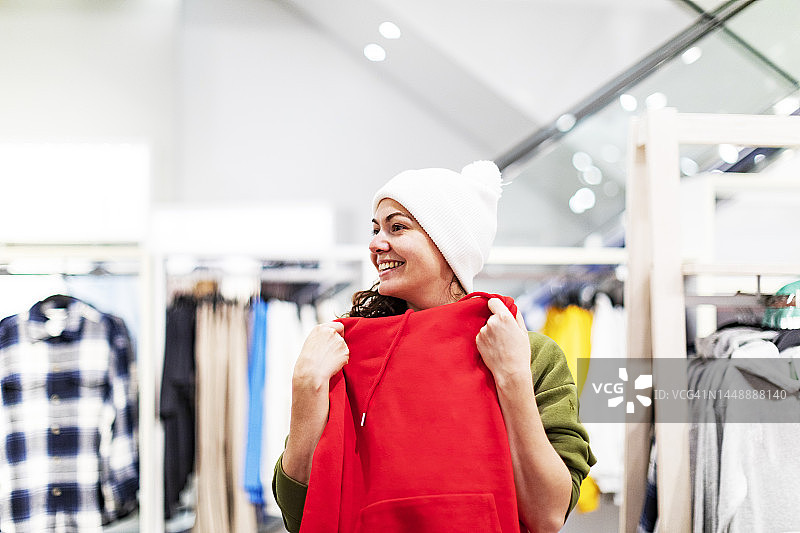 年轻女人在商店购买衣服图片素材