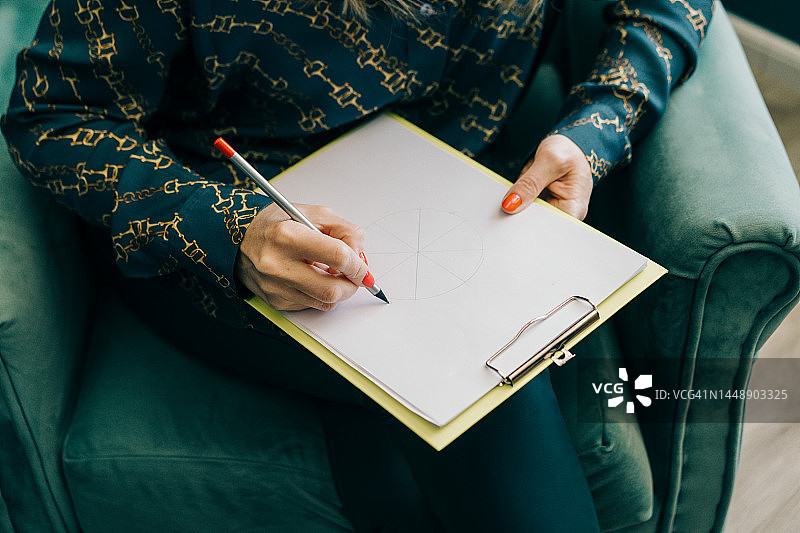 一位中年金发女性坐在扶手椅上进行远程工作，线上心理咨询图片素材