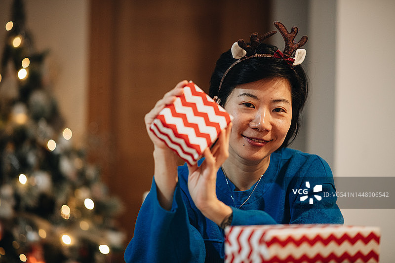 展示新年礼物的年轻亚洲女性图片素材
