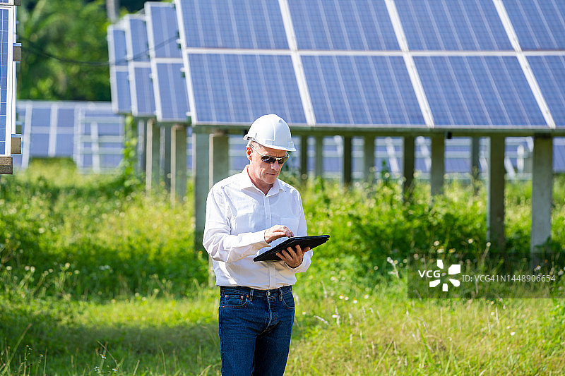 工程师使用平板电脑在太阳能电池板厂工作和检查图片素材