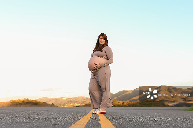 孕妇站在路上的黄色标线上图片素材