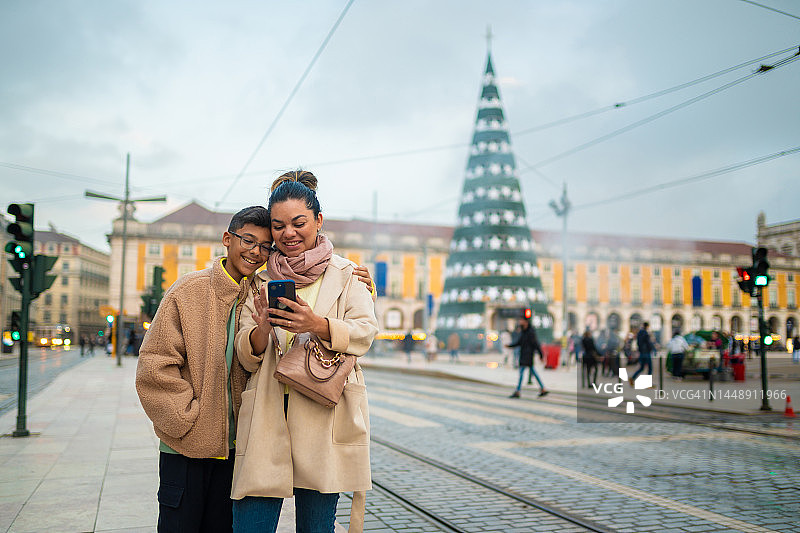 在里斯本过圣诞节时使用智能手机的人们图片素材