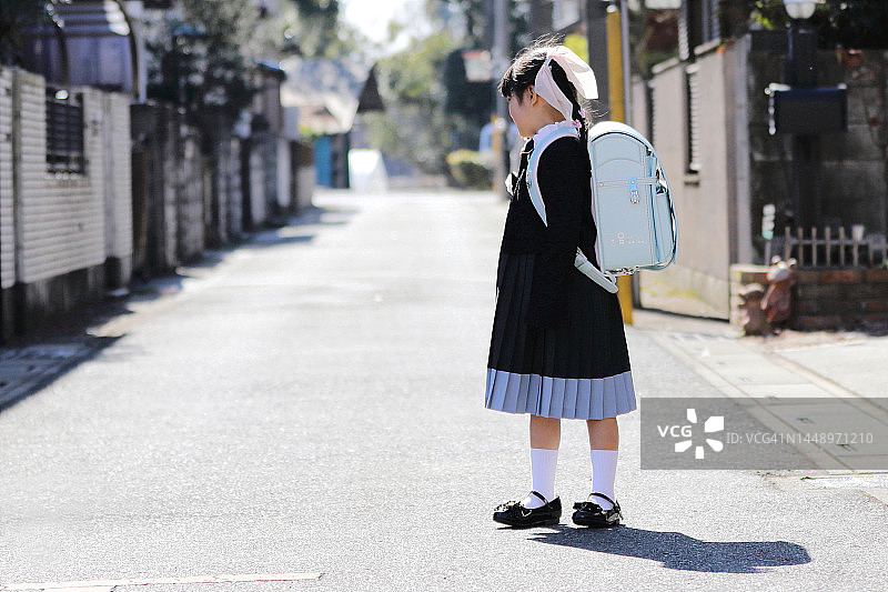 小学生入学典礼。穿着正式服装、背着书包的小孩。全身照图片素材