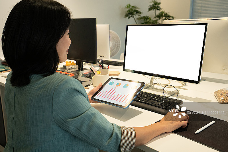 亚洲白领使用平板电脑在办公室检查数据图片素材