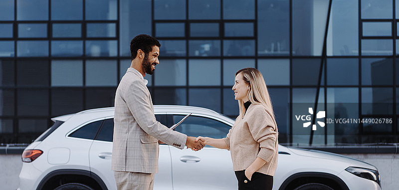 年轻女销售展示电动汽车图片素材
