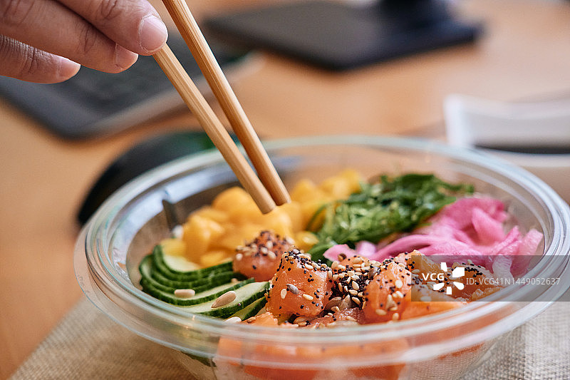 某人拿着筷子吃夏威夷盖饭的手图片素材