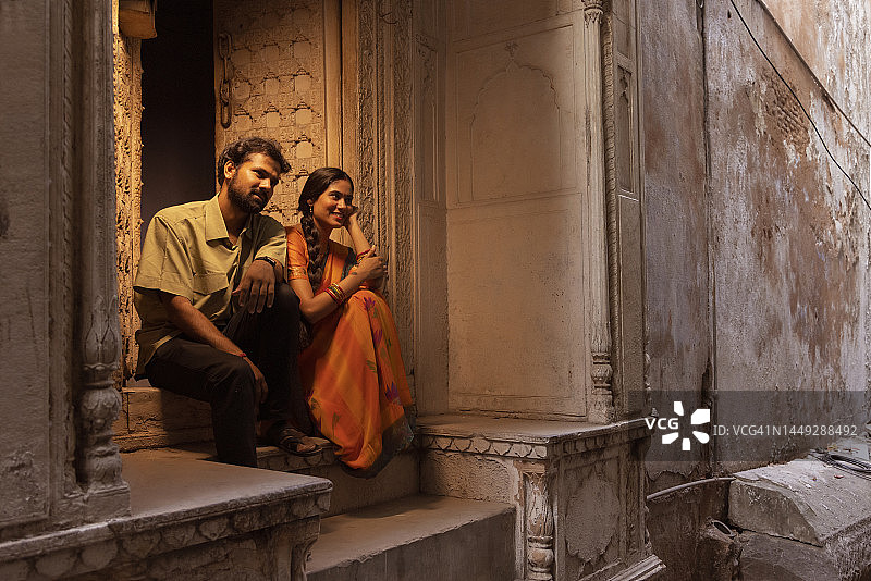 年轻情侣一起坐在门阶上的肖像图片素材