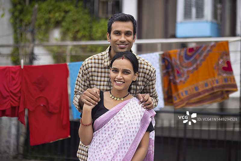 快乐的年轻情侣站在后院的合影图片素材