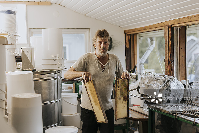 男人拿着蜂箱框图片素材