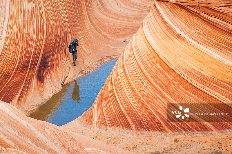 在亚利桑那州朱红悬崖北部狼丘的波浪岩层上行走图片素材