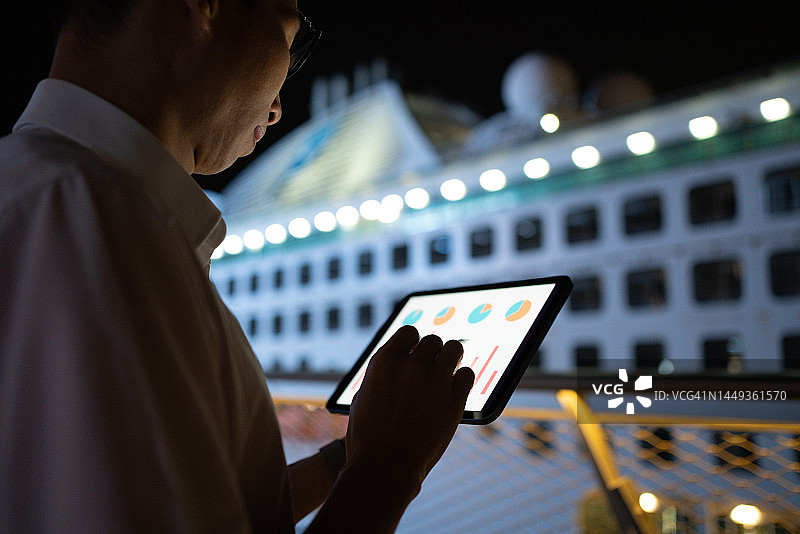 在户外夜晚使用平板电脑的亚洲男人图片素材