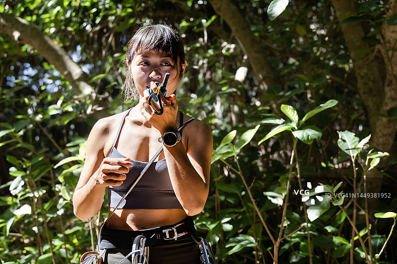 年轻女登山者使用对讲机图片素材