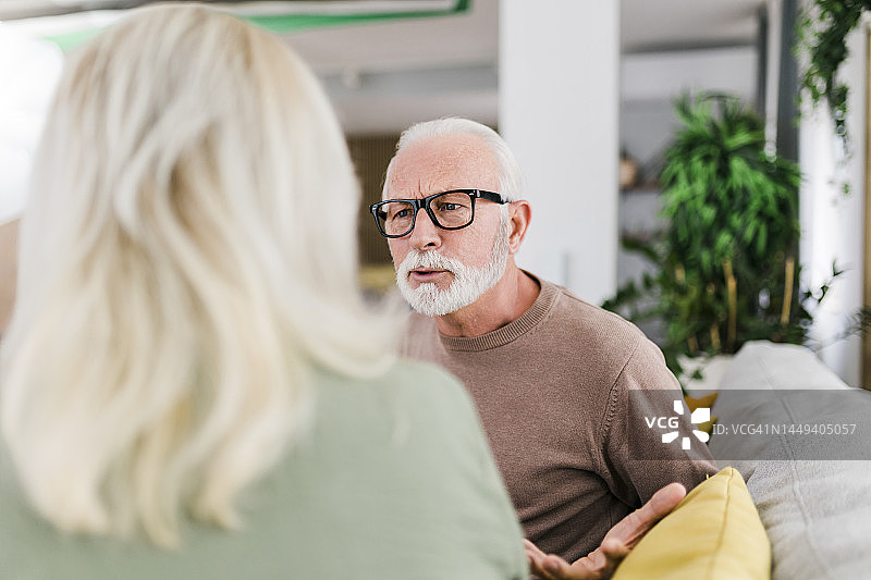 年长的异性夫妇在家里的沙发上争吵图片素材