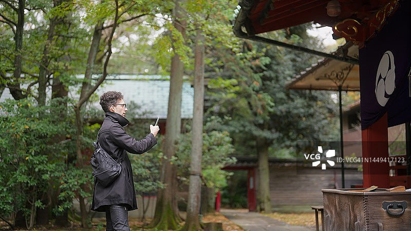 男游客参观神社并享受拍照的乐趣图片素材