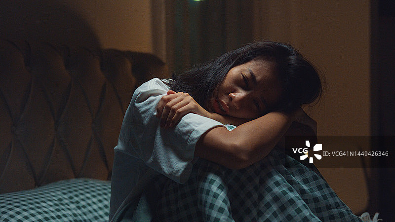 悲伤沮丧的亚洲女孩在床上。孤独的人有压力、失眠和睡眠问题。图片素材