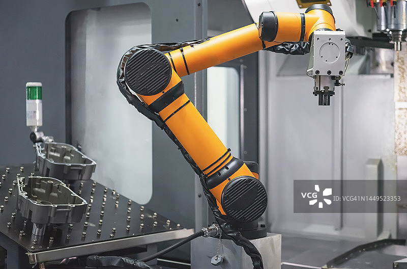 机器手臂在制造工厂中将零件输送到数控机床图片素材