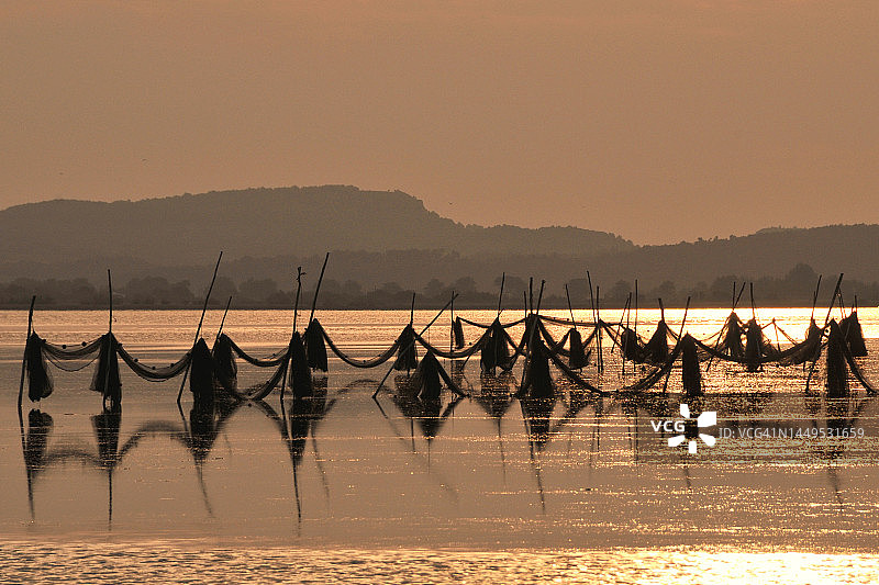 日出时池塘上的渔网图片素材
