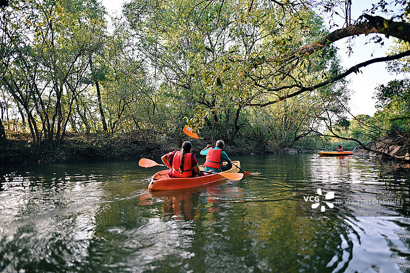 河边森林中老年夫妇皮划艇背影图片素材