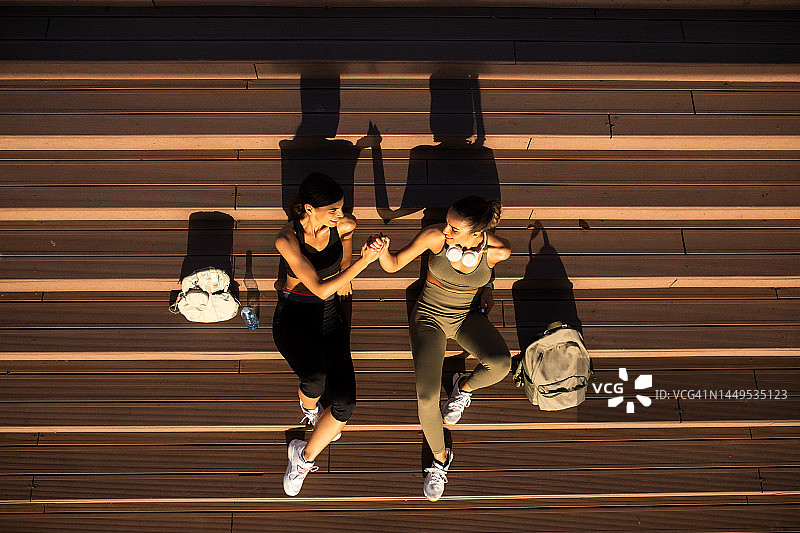 两位跑步后在台阶上休息的女性朋友图片素材