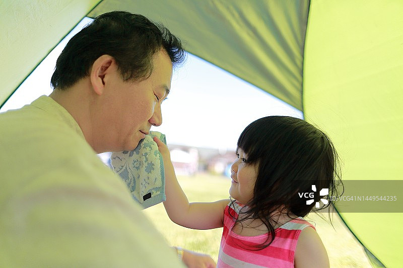 可爱的孩子用毛巾擦去父亲脸上的汗水图片素材