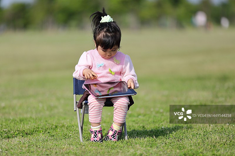 儿童在户外学习使用无线科技平板电脑图片素材