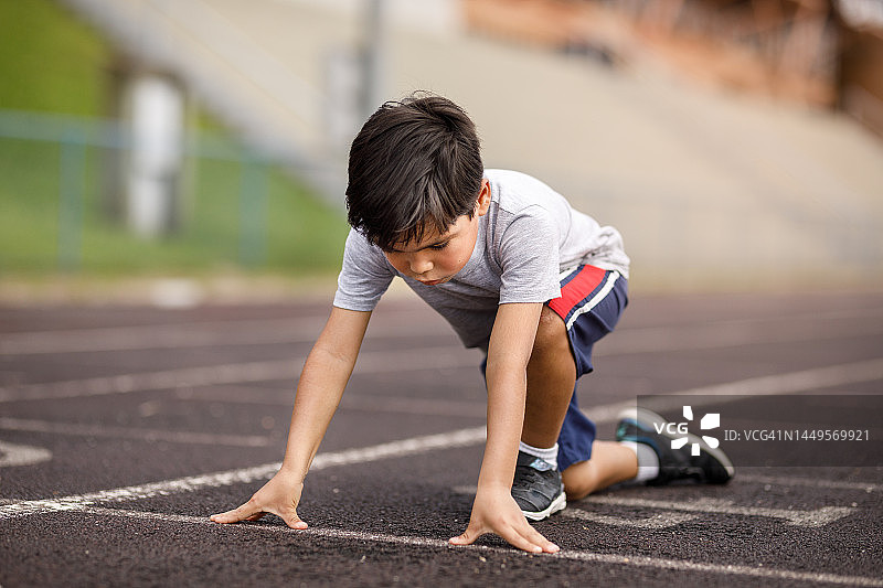 赛道上处于预备姿势的小男孩图片素材