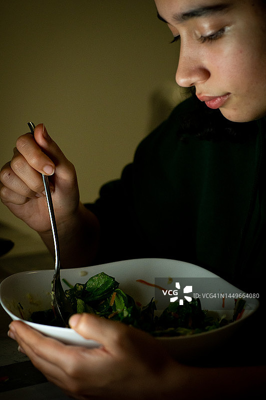 年轻女人享用健康的晚餐沙拉图片素材