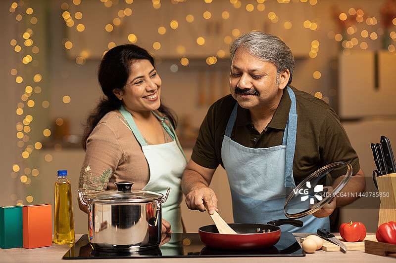 笑容满面的情侣在家准备食物图片素材