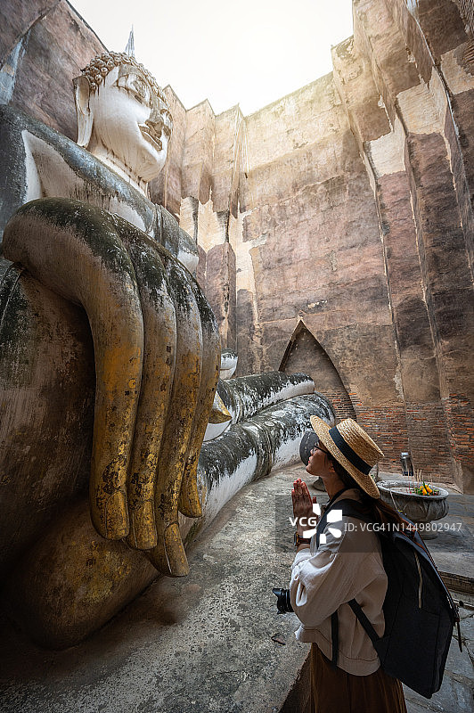 在泰国素可泰历史公园西春寺，向“阿迦纳佛”祈祷的亚洲女游客图片素材