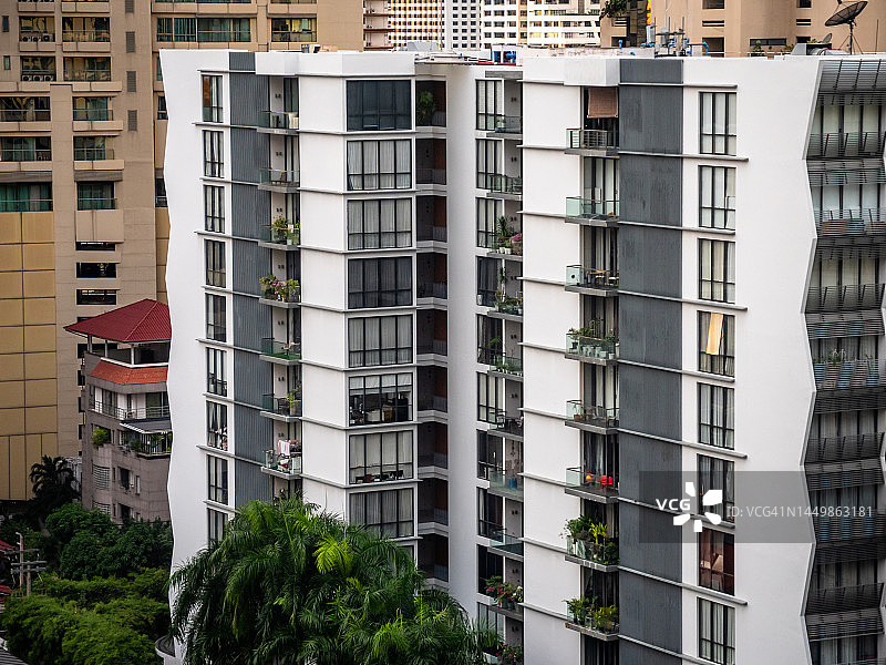 曼谷城市公寓楼房与绿树植物的城市景观特写：ESG、房地产、城市生活、绿色气候与地产概念图片素材