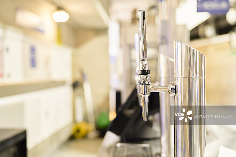餐厅或场馆内的银色金属啤酒龙头侧视图图片素材