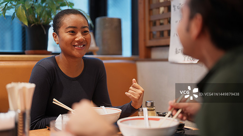 旅行中享用拉面的两位多种族朋友游客图片素材
