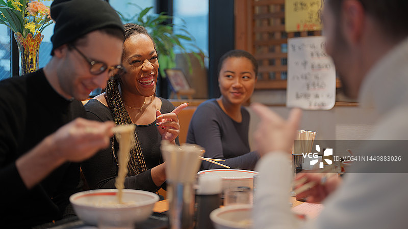 拉面店里享用日式拉面的多民族游客图片素材