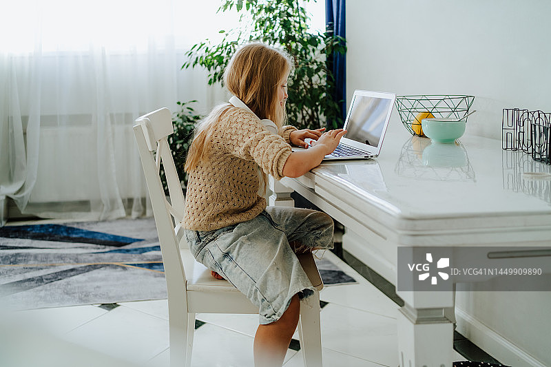 使用笔记本电脑搜索学校信息的小女孩图片素材