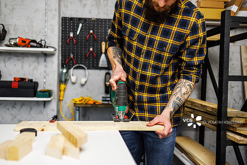 男人用曲线锯切割木头图片素材