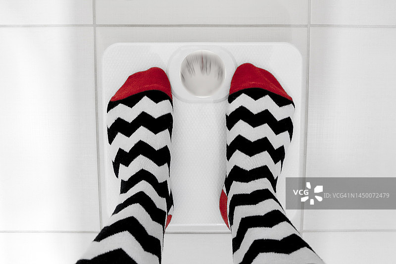 站在体重秤上的女人足部图片素材