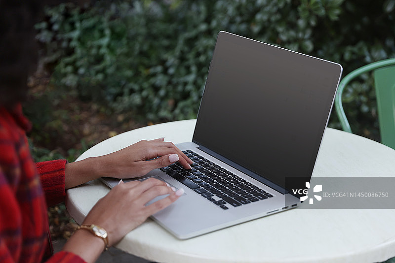 非裔美国女性在户外咖啡馆使用笔记本电脑图片素材