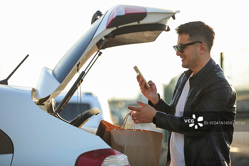 青年男子购物，使用手机，发短信，城市生活图片素材