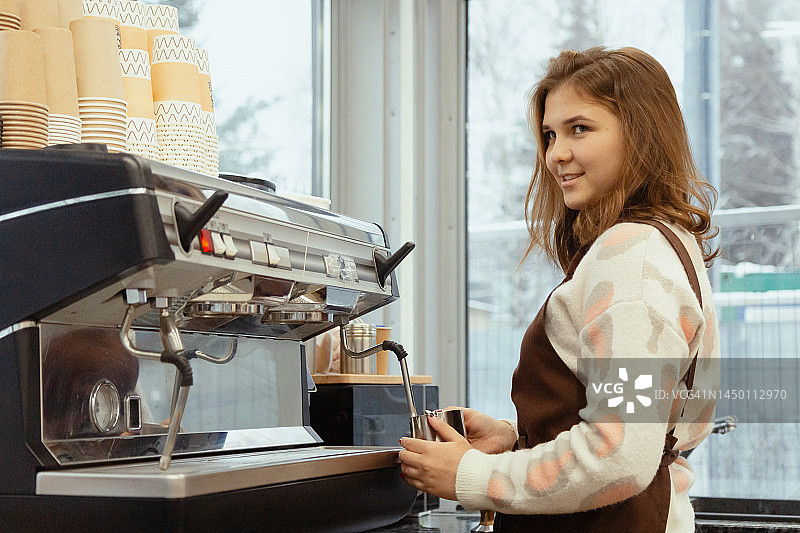 少女在自助餐厅工作，年轻的咖啡师女孩准备咖啡图片素材