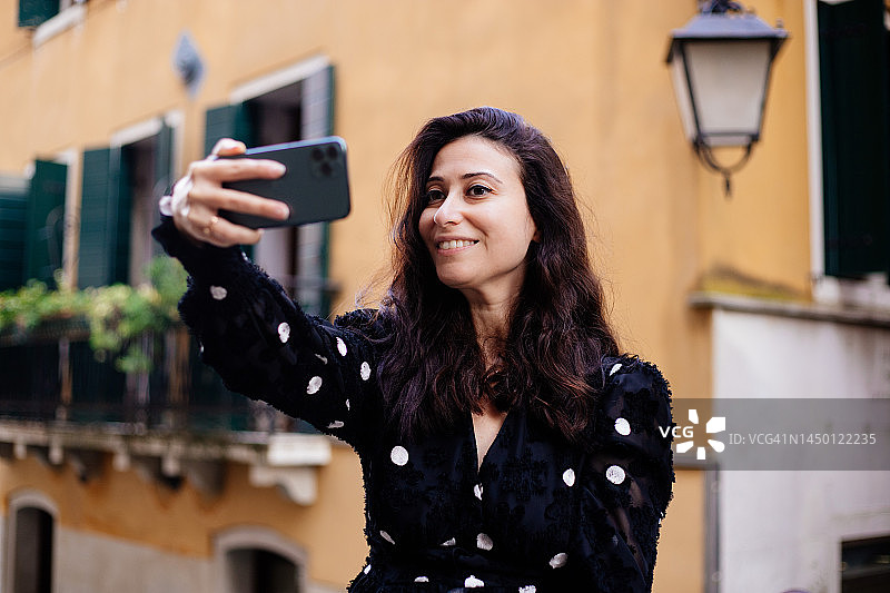 在威尼斯房屋前自拍的女人图片素材