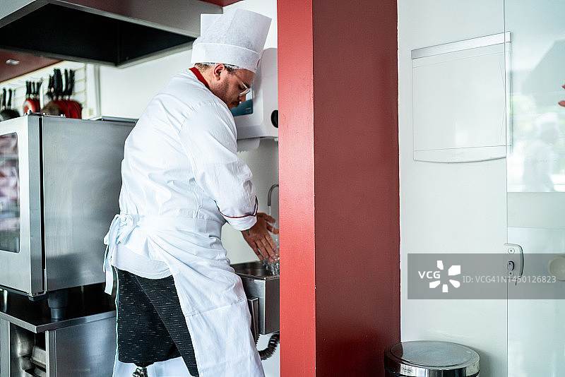 在商用厨房洗手的残疾厨师图片素材