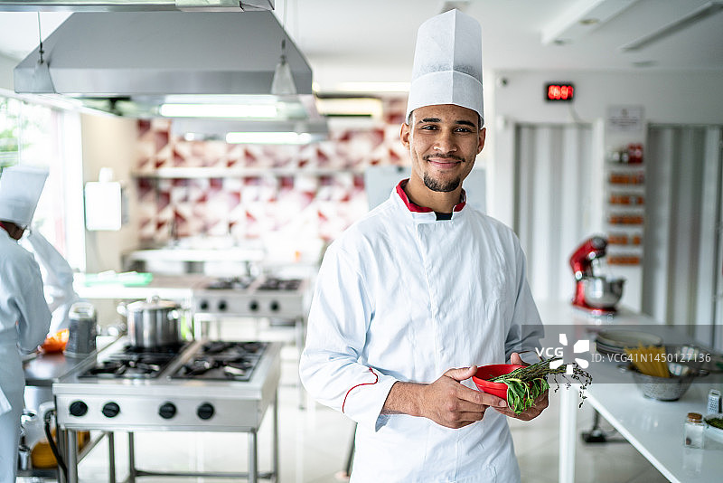 在厨房手持香草的厨师肖像图片素材