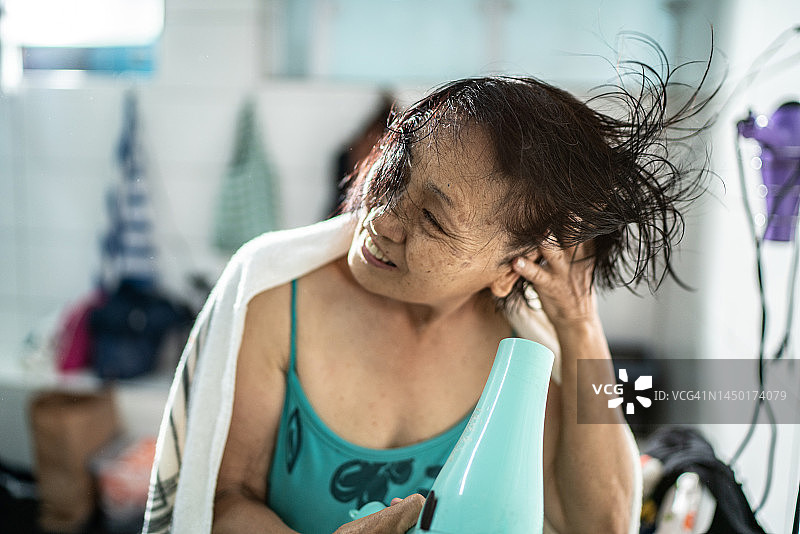 年长的女人游泳课后吹干头发图片素材