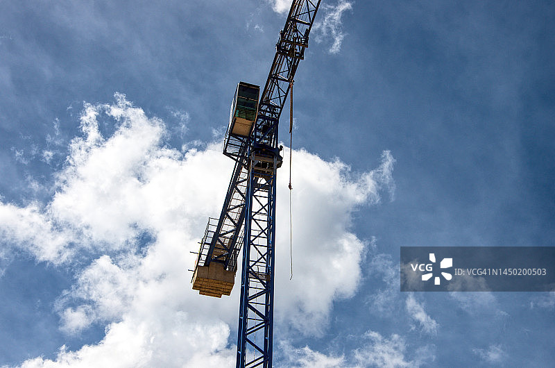晴朗多云天空下的建筑工地上的大型建筑起重机图片素材