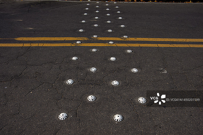 沥青路上排列的小型减速带，带黄色双线标记图片素材