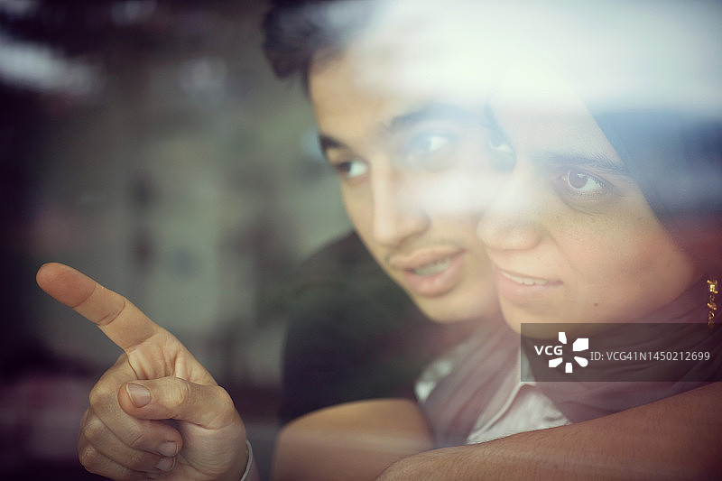 穆斯林母亲和十几岁的儿子在窗边图片素材