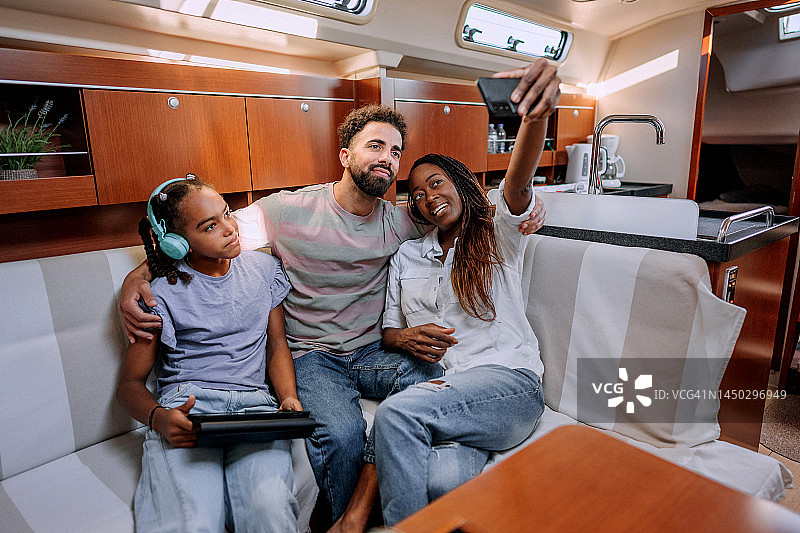 年轻家庭在游艇舱内自拍图片素材