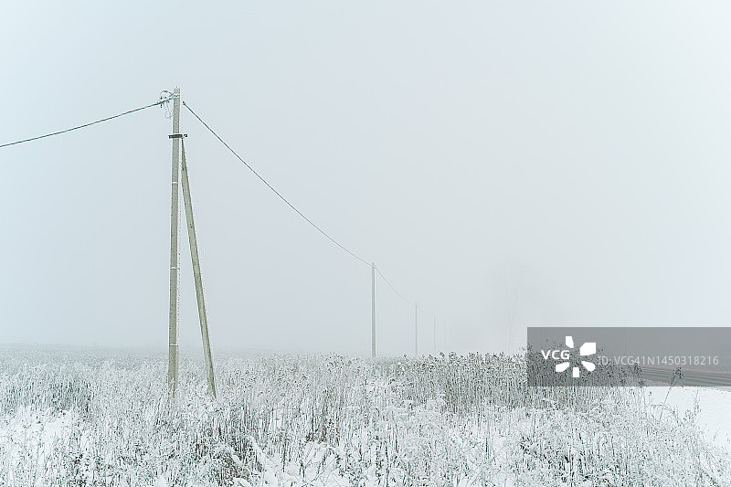 雪地里的电话电线杆和电力线图片素材